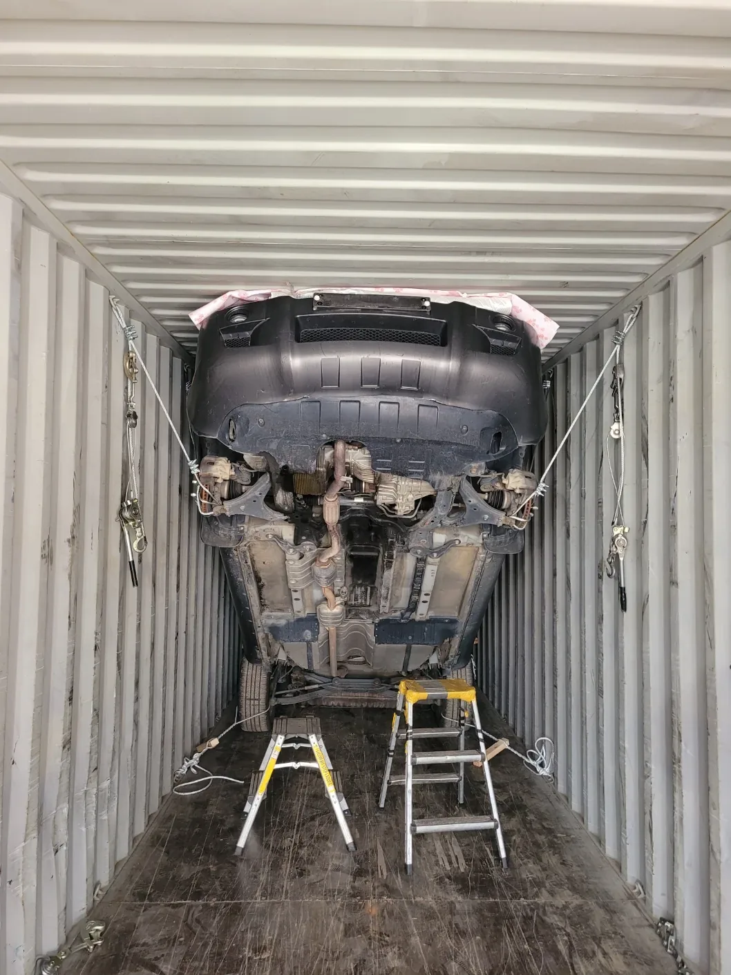 Lashing straps anchored under vehicle